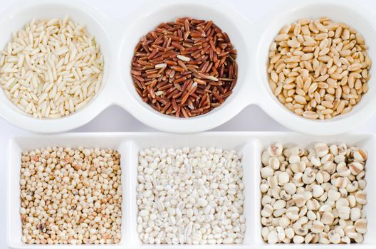  rice , red rice , wheat,  job's tears , barley and millet grains on white bowl