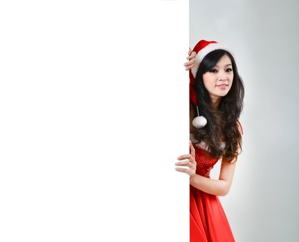 Santa woman  holding a white poster isolated a on gray background