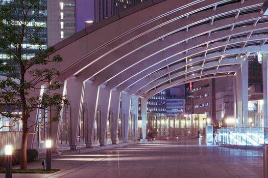modern architecture outdoor pathway under arc glass roof in the night