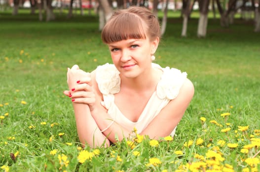 beautiful young woman lying on the grass in the park, good emotions