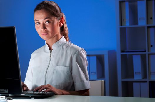 beautiful young woman doctor working at night in the office