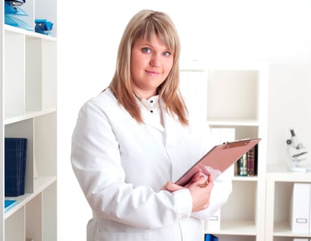 portrait of a young woman doctor with a clipboard, smiling