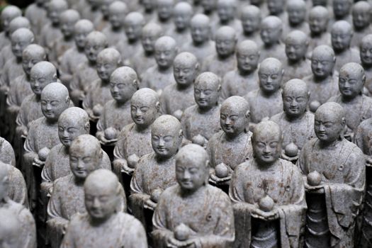 rows of similar japanese jizo sculptures in Hase-Dera temple, Kamakura, Japan;
focus on central part