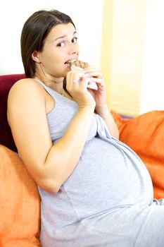 Gorgeous female model pregnant eating chocolate