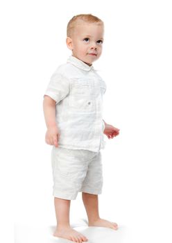 Full length portrait of a happy little boy standing isolated over white background