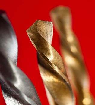 macro of a metal drilling bits on red background