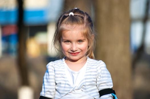 Cute little girl on outdoor playground equipment