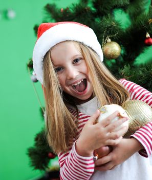 Smiling girl in red Santa hat with Christmas decoration