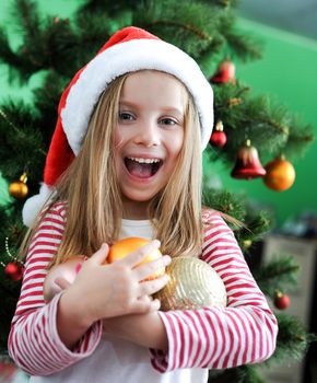 Smiling girl in Santa hat with Christmas decoration