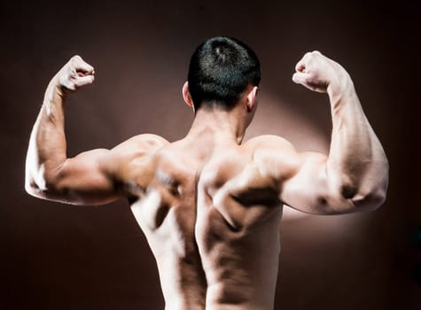 muscular male back on brown background
