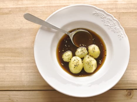 close up of a plate of boiled potatoes in brown sauce