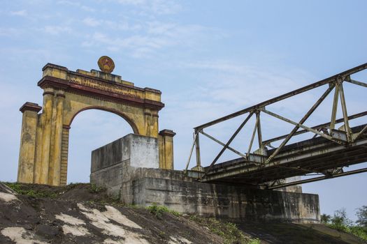 Dilapidated yellow and red structure against blue skies.