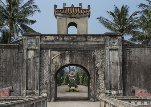 Gate to the historic site covered with black mold and fronted by couple of canons.