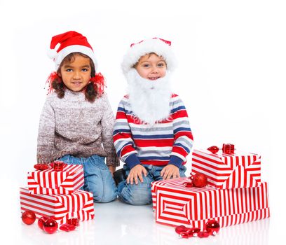 Smiling little mullato girl and her brather in Santa's hat with gift box, isolated on white
