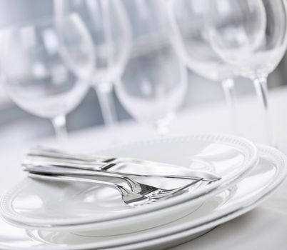 Elegant restaurant table setting with plates cutlery and stemware
