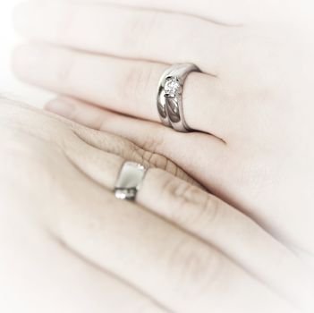 Closeup on hands of married couple with wedding rings