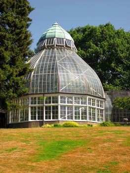 A photograph of a greenhouse located in a public park.