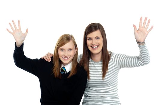 Mum and daughter waving hands at the camera. Having fun together.