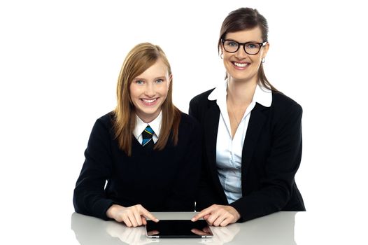 Tutor and student duo operating tablet pc. Facing camera and smiling.