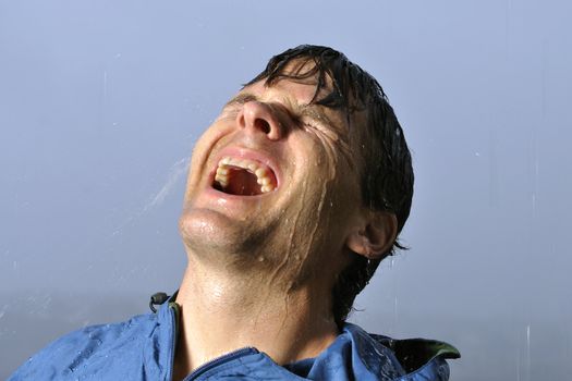 Closeup of drenched man having fun in the rain