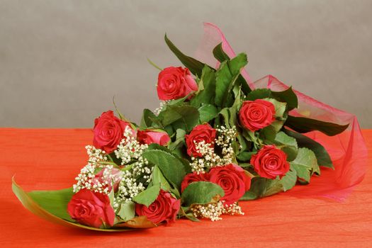 Bouquet of fresh red roses on gray background, with space for copy in the side
