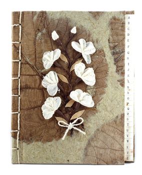 Brown mulberry paper book isolated with white flower.