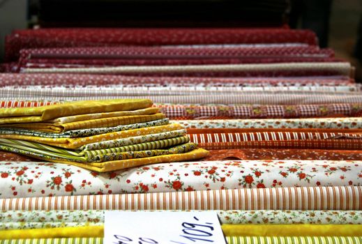 Big assortment of fabrics in the textile store 