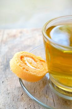 Roll cake and cup of tea on wood background