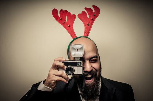 christmas bearded man holding old camera on grey background