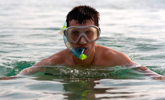 The man in the sea in a mask with a tube