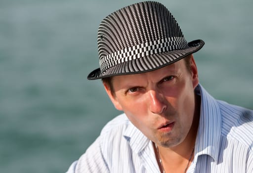 portrait of a man in a hat amazed at the background of the azure sea