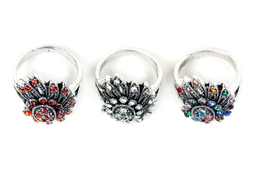 Three silver rings with precious stones on a white background