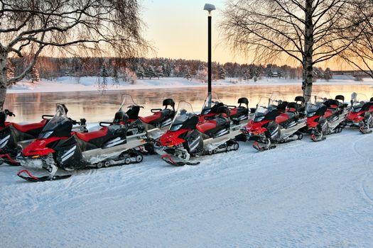 Vehicles are a number of snowmobiles in the parking lot