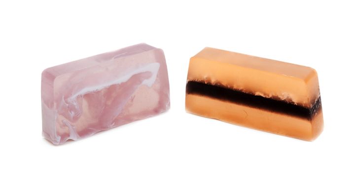 Two pieces of fruit soap on white background