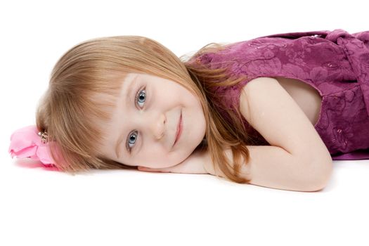 beautiful girl aged four years lying on the floor. Isolate on white