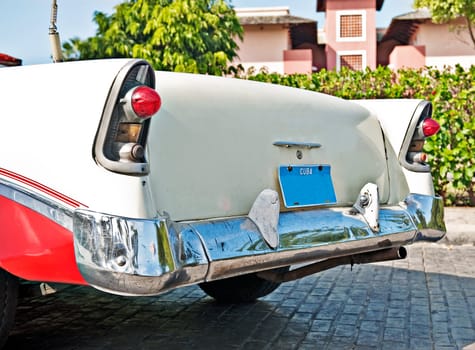 A 56 red and white Chevy that is driven on the road in cuba