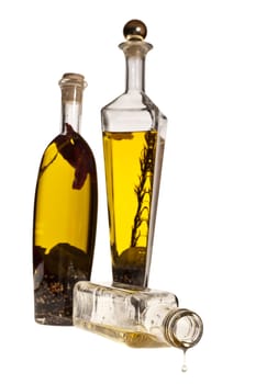 LAst drop of oil image on white background with bottles of oil at second plane