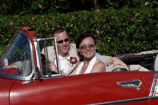 Husband and wife portrait sitting in classic car