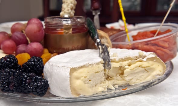 Tray with cheese, grapes, blackberries on the table