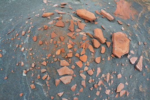 Placer rusty rocks on the hill of black sand. background