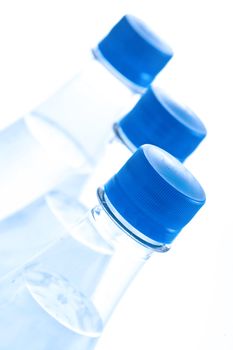 Bottles of water with bubbles on white background