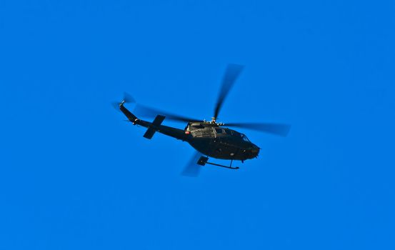 Flying helicopter on a blue sky