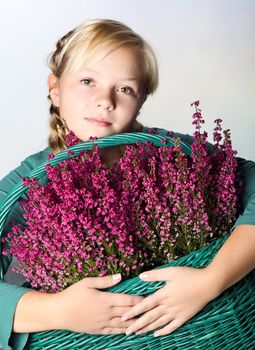 Beautiful girl with a basket of Purple heather flowers