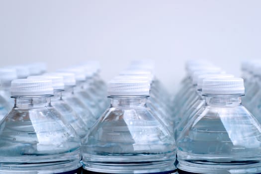 Rows of Bottles of water with bubbles on white background