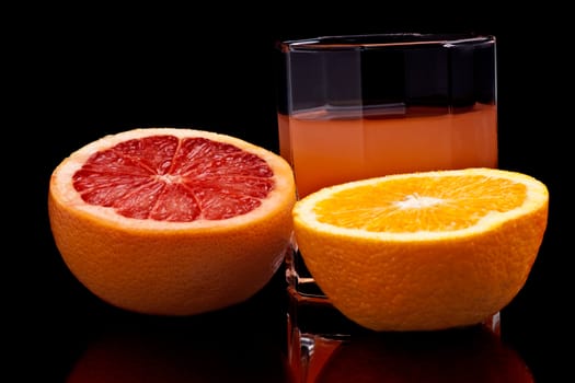 Glass of Grapefruit and orange juice on the black background