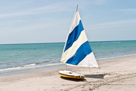 Small sail boat on a sandy beach