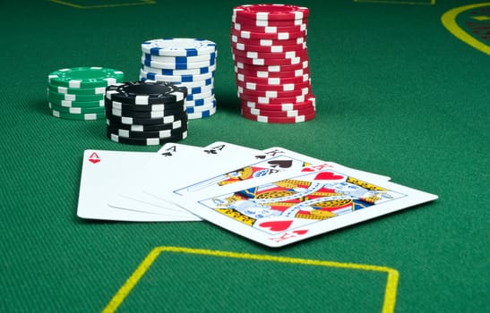 Full house of aces over kings with stacks of poker chips