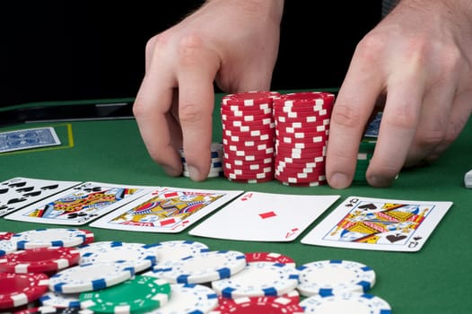 All in motion with five cards face up in front of a pot of chips