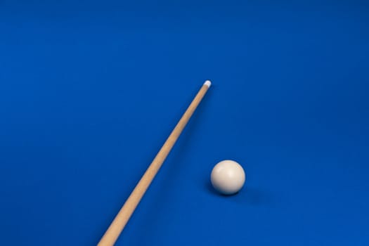 cue tip on the pool table with white ball at a game of billiards