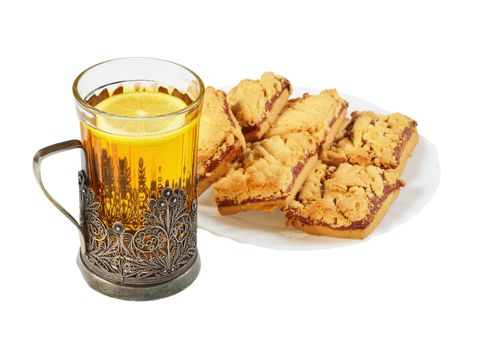 Tea in a glass in the cup holder and saucer with cookies.